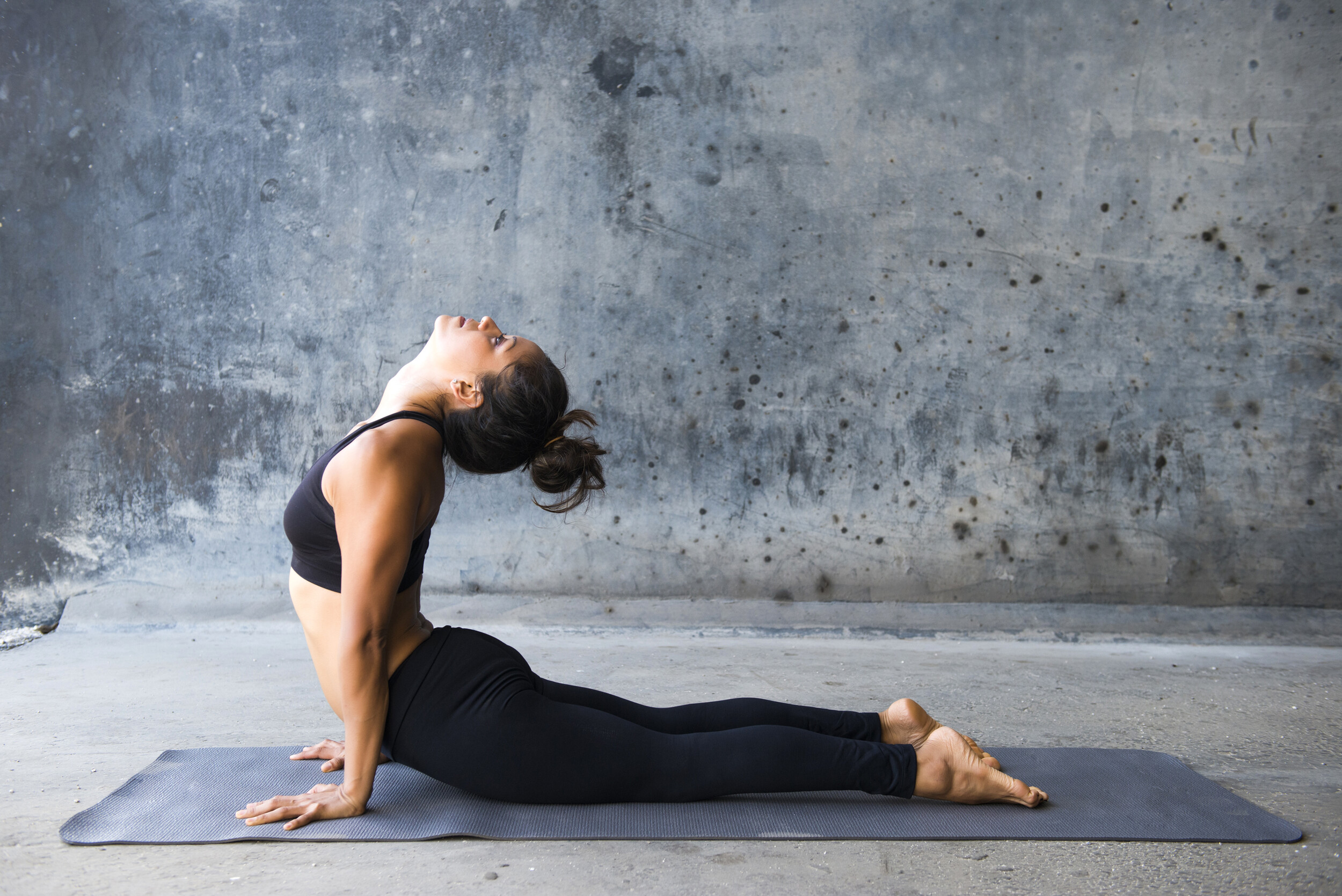 Junge Yoga Praktizierende vor städtischem Hintergrund